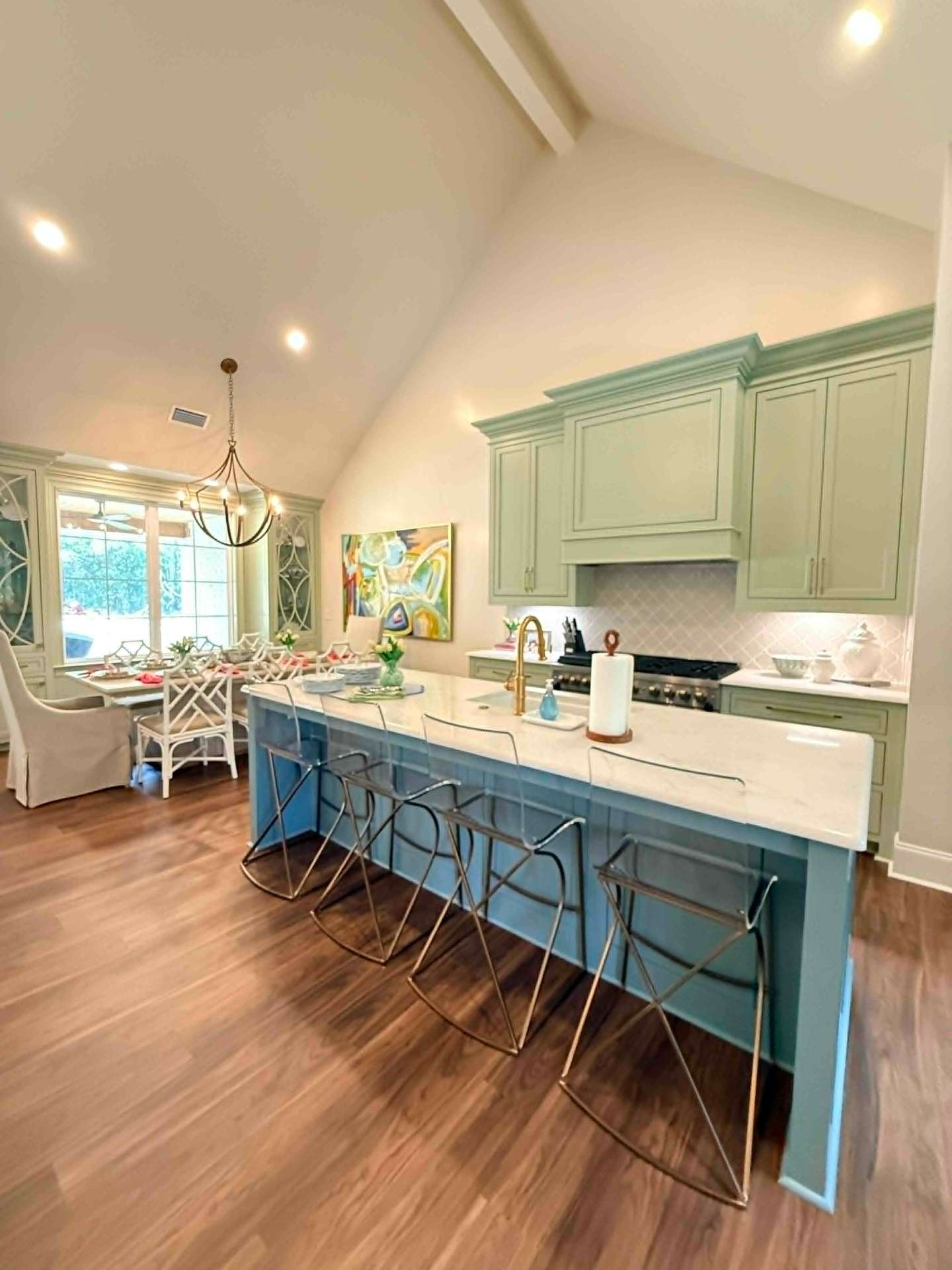 A vaulted sage kitchen with custom cabinetry